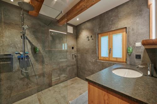 a bathroom with a sink and a shower at Chalet´s am See in St. Wolfgang