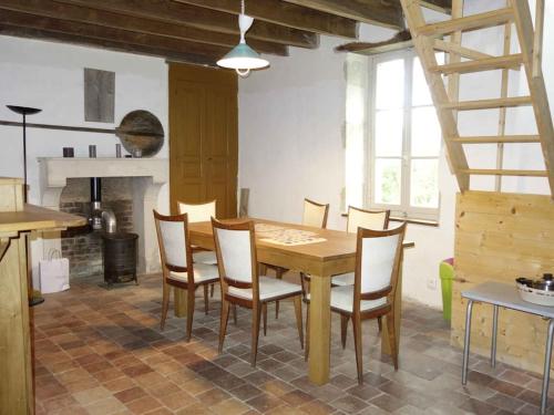 ein Esszimmer mit einem Holztisch und Stühlen in der Unterkunft Sous les chênes – Gîte nature dans le Berry Sud in Saint-Saturnin