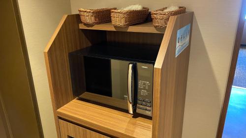 a microwave on a wooden shelf in a kitchen at Onyado Nono Matsue Natural Hot Spring in Matsue
