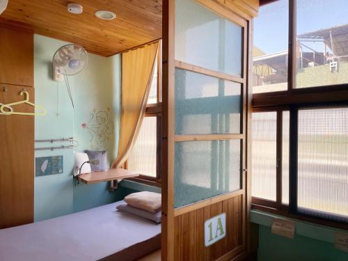 a room with a window and a bed in a room at Fuqi Hostel - Heping in Tainan