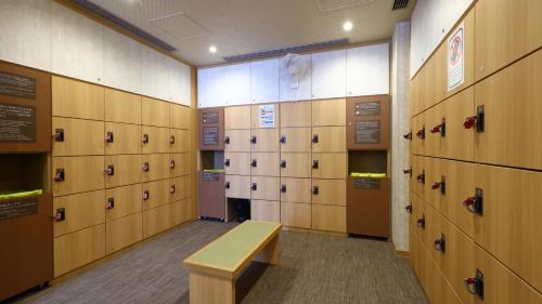a room with lockers and a bench in a gym at Onyado Nono Matsue Natural Hot Spring in Matsue