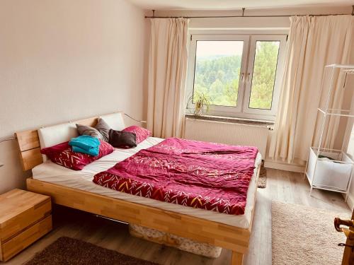 łóżko w pokoju z dużym oknem w obiekcie Fewo Bergblick w mieście Kurort Oberwiesenthal