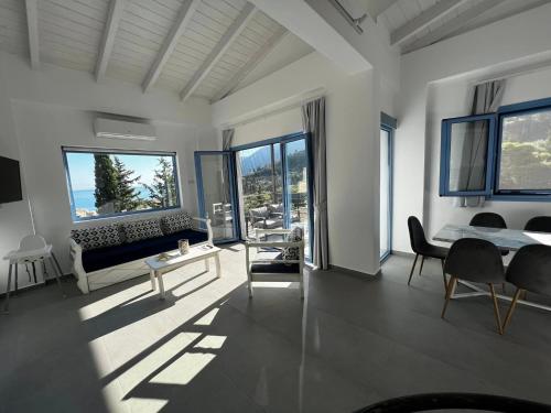 a bedroom with a bed and a couch and windows at Katerinas Village Supreme Villas with private pool in Agios Nikitas