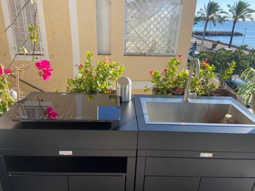 a kitchen with a sink and some flowers on a counter at Ô Phare du Cros in Cagnes-sur-Mer