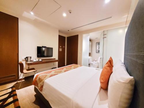 a hotel room with a bed and a television at On 8 Sukhumvit Nana Bangkok by Compass Hospitality in Bangkok