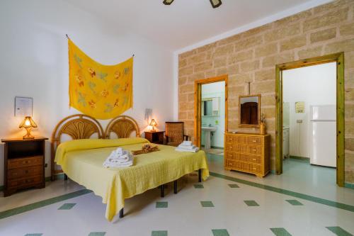 a bedroom with a bed with a yellow bedspread at Domus mea salento Arazzo Giallo in Ugento