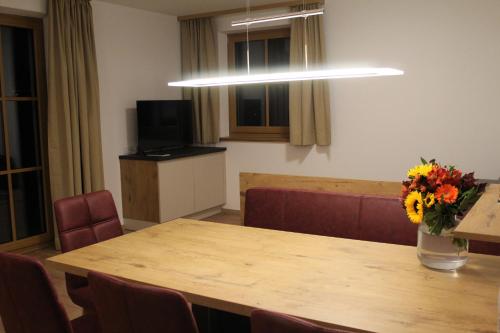a conference room with a table and a vase of flowers at Landhaus Eiter in Arzl im Pitztal
