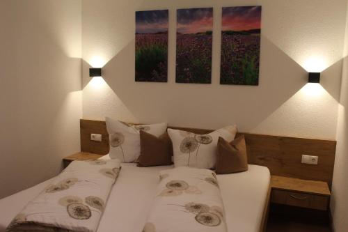 a bedroom with a bed with two pillows and two lamps at Landhaus Eiter in Arzl im Pitztal