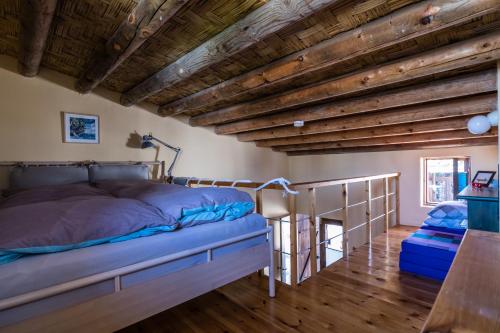 een slaapkamer met een bed en een houten plafond bij Guesthouse Gonia in Pera Orinis