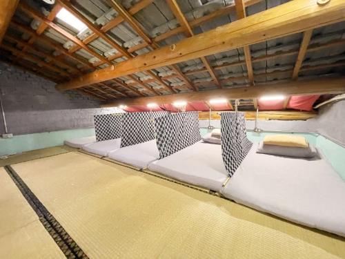 a room with four beds in a room with a ceiling at Fuqi Hostel - Heping in Tainan
