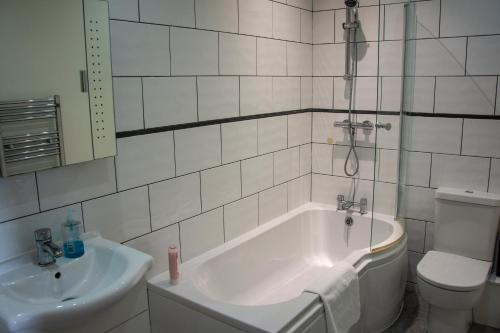 a bathroom with a tub and a toilet and a sink at Morecambe Central balcony with sea view in Morecambe