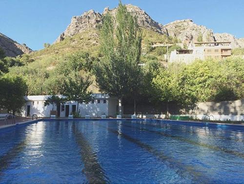 une grande piscine d'eau avec une montagne en arrière-plan dans l'établissement Entre montañas, à Dos Aguas