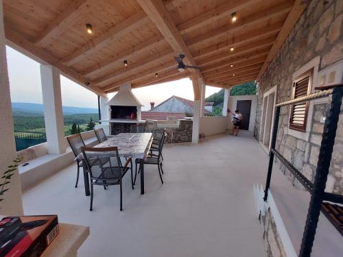 eine Terrasse mit einem Tisch, Stühlen und einem Kamin in der Unterkunft Private pool villa - Meditteranean peace in Slano