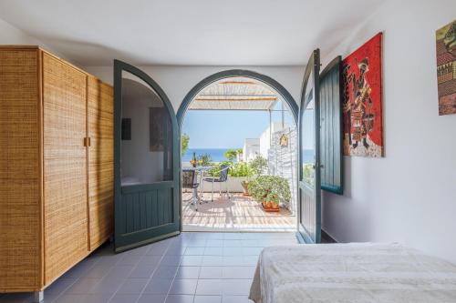 een slaapkamer met een open deur naar een patio bij Isulidda Gaia Mare in San Vito lo Capo