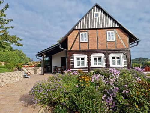 a house with flowers in front of it at Luxusní apartmán s krbem - Kunratické Švýcarsko in Kunratice