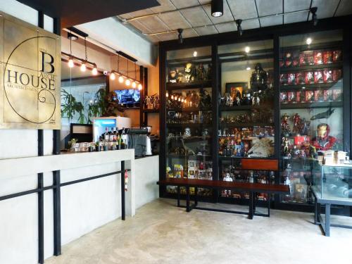 a bar with a lot of bottles of alcohol at B+Arch House / Hotel&Cafe in Chiang Mai
