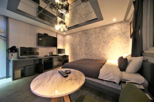 1 dormitorio con cama y mesa de madera en The Gentle Hotel en Busan