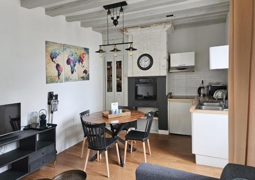 eine Küche und ein Esszimmer mit einem Tisch und Stühlen in der Unterkunft Le nid perché dans la doutre in Angers