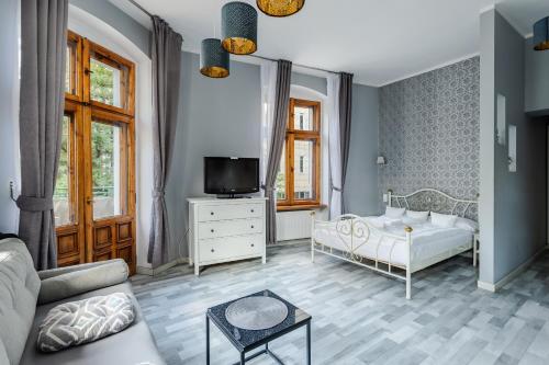 1 dormitorio con 1 cama, TV y sofá en Very Berry - Glogowska 35m10 - MTP Apartments - self check in 24h -, en Poznan