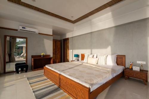 a bedroom with a large bed and a desk at StayVista's Casa Bella - Sea-View Villa with Infinity Pool, Jacuzzi, Games, Entertainment, and Spa Room in Alibaug