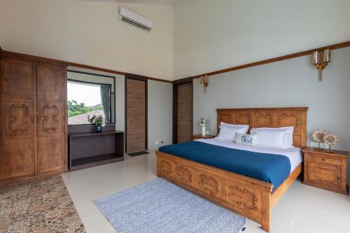 a bedroom with a large bed and a window at StayVista's Casa Bella - Sea-View Villa with Infinity Pool, Jacuzzi, Games, Entertainment, and Spa Room in Alibaug