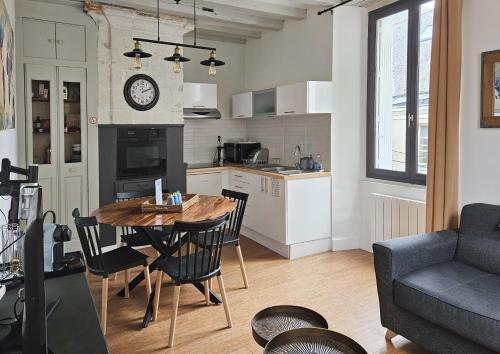 eine Küche und ein Wohnzimmer mit einem Tisch und Stühlen in der Unterkunft Le nid perché dans la doutre in Angers