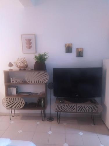 a living room with a flat screen tv and a table at Sofia-Marina Guest House in Xanthi