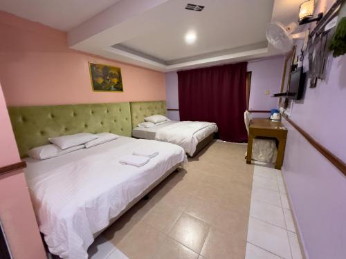 a hotel room with two beds and a television at DNELAYAN BEACH RESORT in Masjid Tanah