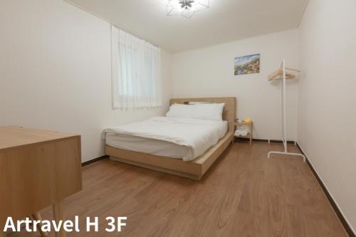 - une chambre avec un lit et du parquet dans l'établissement Artravel Hongdae, à Séoul