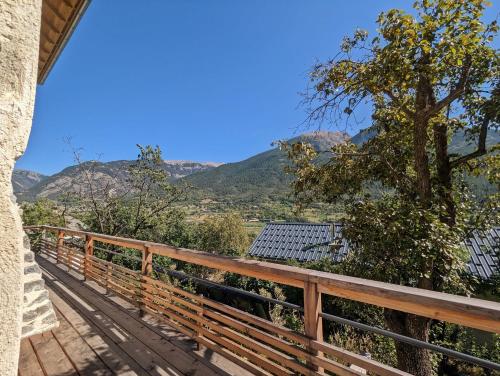 Elle comprend un balcon en bois offrant une vue sur les montagnes. dans l'établissement Villa Panorama - 120m2, 8 pax, 6mn des pistes, rénové, plein sud, à Puy-Saint-André