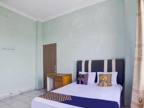 a bedroom with a white bed with colorful pillows at SPOT ON 92904 Penginapan Pakam in Lubukpakam