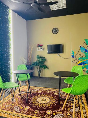 a waiting room with two tables and green chairs at AK Greenrise Meru in Ipoh