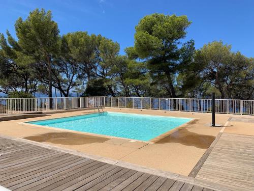 une piscine avec une clôture et des arbres dans l'établissement Horizon Bleu Bandol : appartement pieds dans l’eau, à Bandol