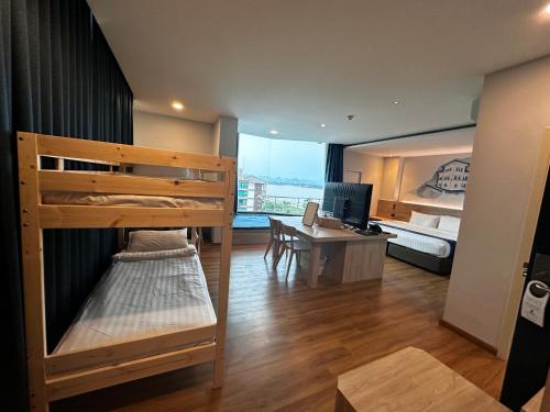 a room with a bunk bed and a desk with a computer at Siri regent Hotel in Nakhon Phanom