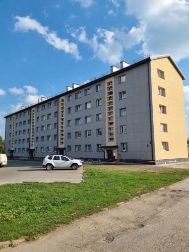 a building with a car parked in front of it at Swan City Family Apartment in Gulbene