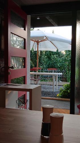 - une vue sur la terrasse dotée d'une table et d'un parasol dans l'établissement Haus Rosebud, à Weilheim
