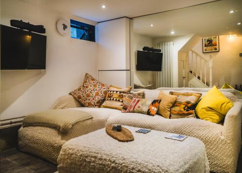 a living room with a couch and a tv at Stunning 2BR, split-level Flat w garden, Deptford in London