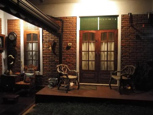 a porch with chairs and a wooden door at night at Roche's Cozy Corner R-2 Ground Level in Sri Jayewardenepura Kotte