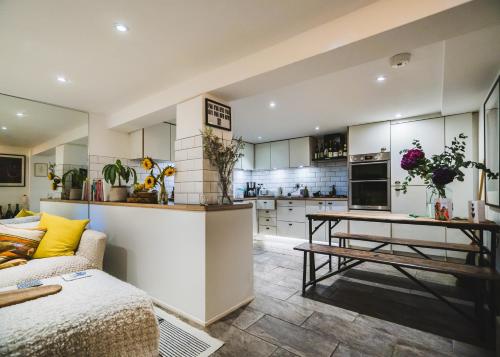 eine Küche und ein Wohnzimmer mit einem Sofa und einem Tisch in der Unterkunft Stunning 2BR, split-level Flat w garden, Deptford in London
