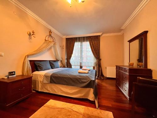 ein Schlafzimmer mit einem Bett, einer Kommode und einem Fenster in der Unterkunft Amazing Luxury 4 BR Apt 200m2 at Fenerbahçe, Best Location in Istanbul