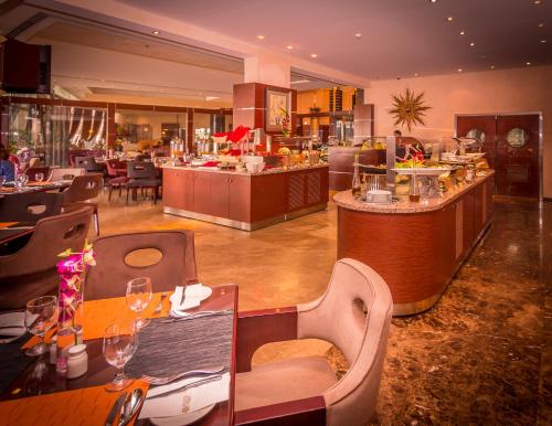 a restaurant with tables and chairs and a bar at City Center Hotel in Manama