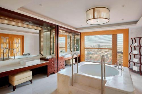 a bathroom with a large tub and a large window at Sheraton Hohhot Hotel in Hohhot