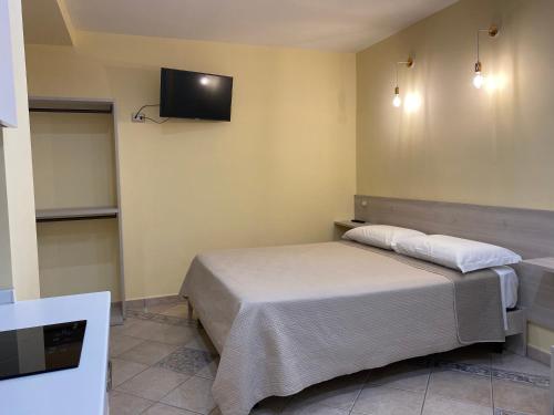 a bedroom with a bed and a tv on the wall at Villa Vittoria in Matera