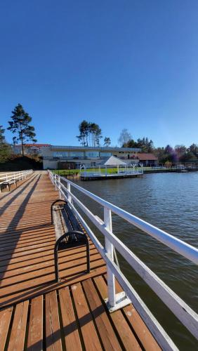 a bench sitting on a dock next to the water at Chëcz Kaszëbsko 59 in Załakowo