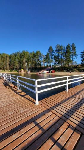 a boardwalk with a white fence and a body of water at Chëcz Kaszëbsko 59 in Załakowo