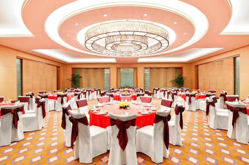 a banquet hall with tables and chairs and a chandelier at Sheraton Jinan Hotel in Jinan
