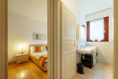 um quarto com uma cama, um lavatório e um espelho em Como Comfort Flat by Wonderful Italy em Como