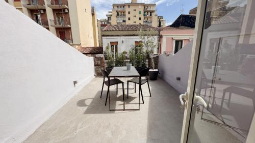 a balcony with a table and chairs on a building at 169Home in Catania