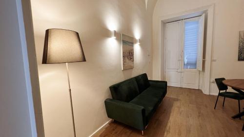 a living room with a green chair and a lamp at 169Home in Catania