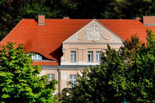 un edificio con techo naranja con un león. en Precise Resort Rügen & SPLASH Erlebniswelt en Sagard